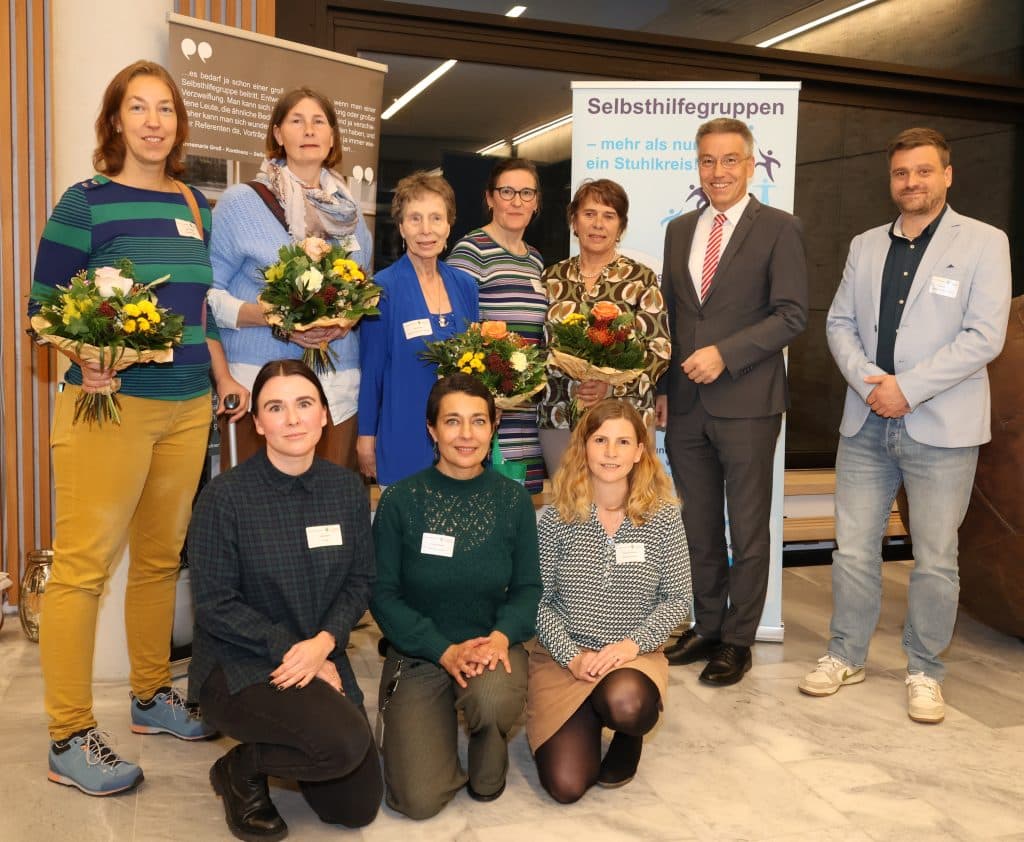 Gruppenbild mit Landrat Otto Lederer. Einige Personen halten einen Blumenstrauß in den Händen.