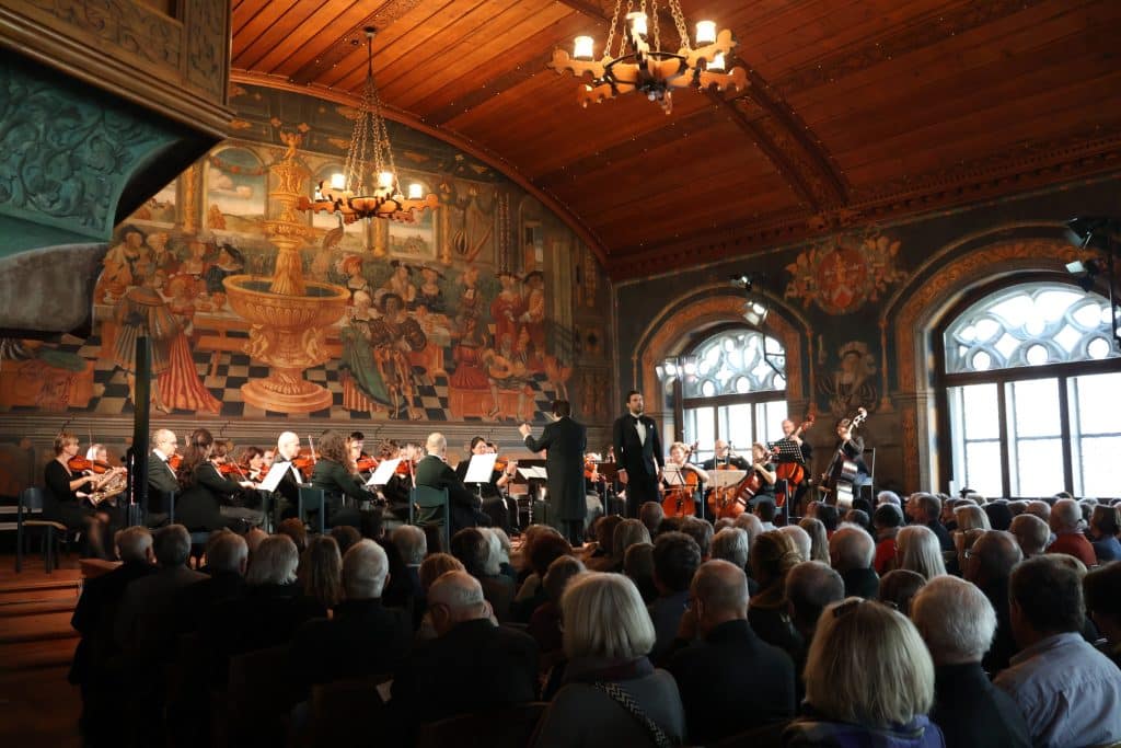 Musiker auf der Bühne im historischen Rathaussaal in Wasserburg am Inn vor Publikum.